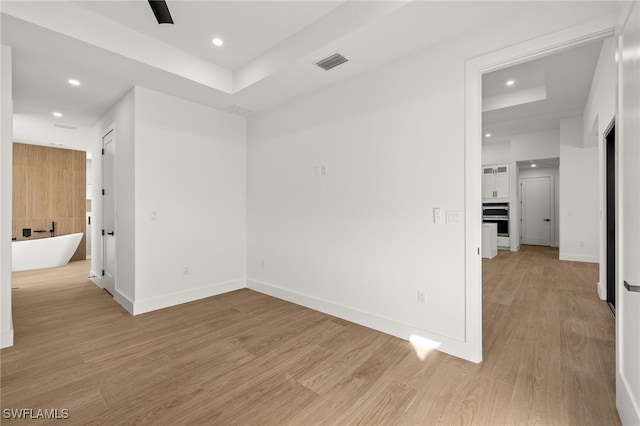 unfurnished room featuring light wood-style floors, baseboards, visible vents, and recessed lighting