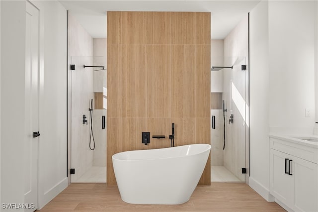 full bath featuring tile walls, a freestanding bath, a shower stall, and vanity