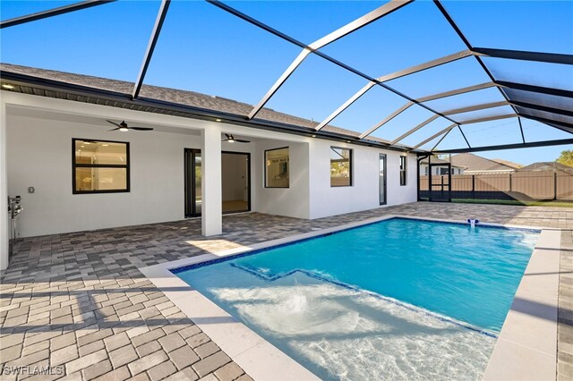 view of swimming pool with a lanai, fence, a ceiling fan, and a patio