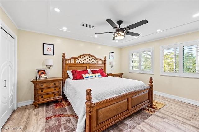 bedroom with a closet, ceiling fan, hardwood / wood-style floors, and crown molding