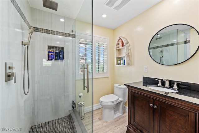 bathroom with wood-type flooring, a tile shower, and toilet