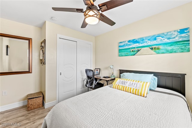 bedroom with a closet, light hardwood / wood-style floors, and ceiling fan