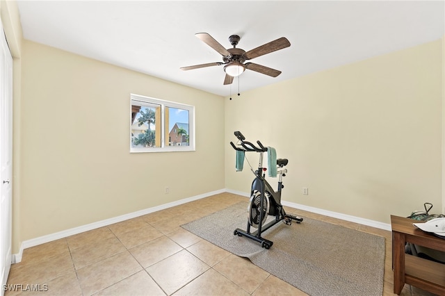 exercise area featuring light tile patterned floors and ceiling fan