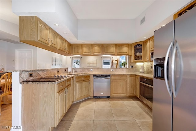 kitchen featuring light stone countertops, light brown cabinets, stainless steel appliances, kitchen peninsula, and light tile patterned flooring