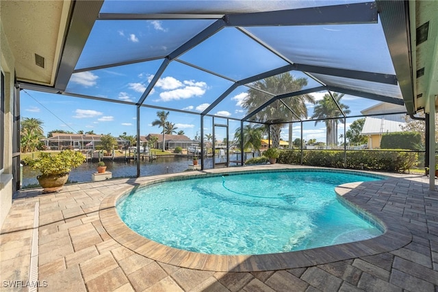 view of swimming pool featuring glass enclosure, a patio area, and a water view