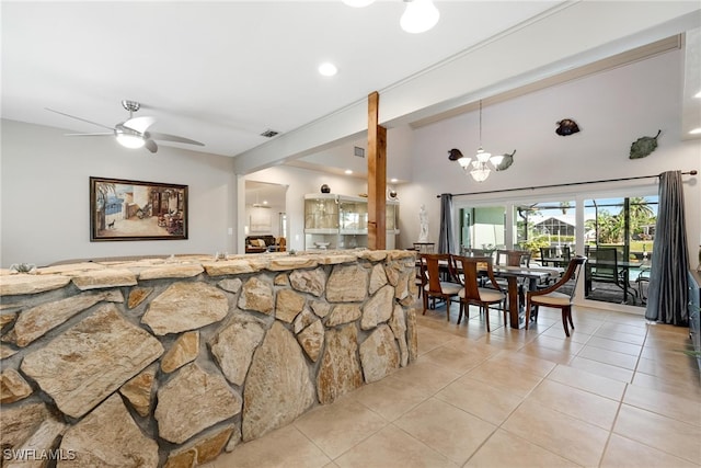 tiled dining room with ceiling fan with notable chandelier