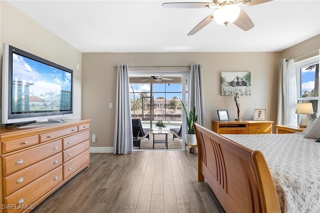 bedroom featuring access to exterior, dark hardwood / wood-style floors, and ceiling fan