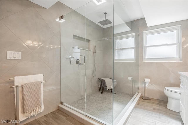 bathroom with walk in shower, tile walls, hardwood / wood-style floors, radiator heating unit, and toilet