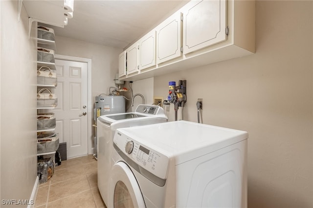 laundry area featuring cabinets, washing machine and dryer, light tile patterned floors, and water heater