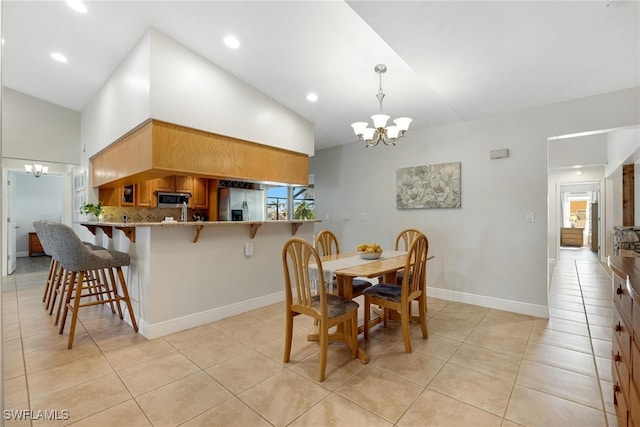 tiled dining space with a chandelier and lofted ceiling