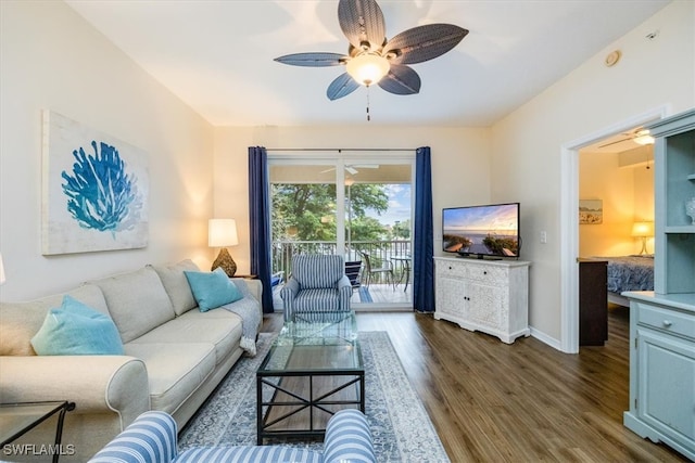 living room with ceiling fan and dark wood-type flooring