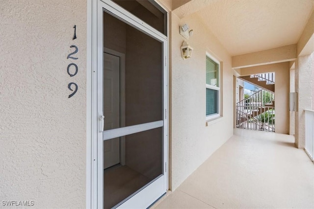 doorway to property featuring stucco siding