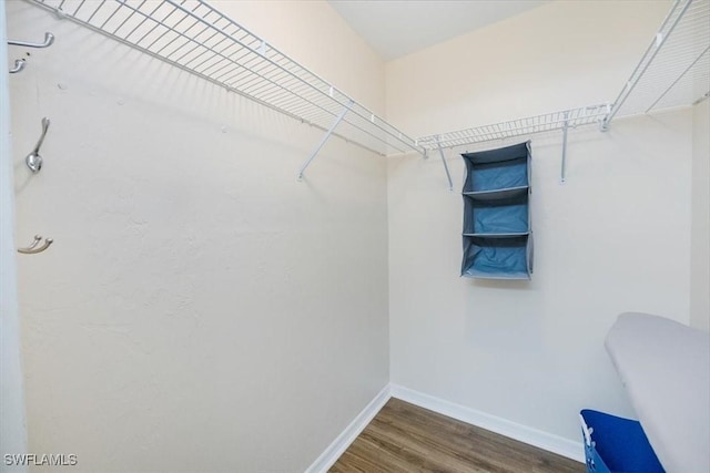 spacious closet with dark wood-style floors