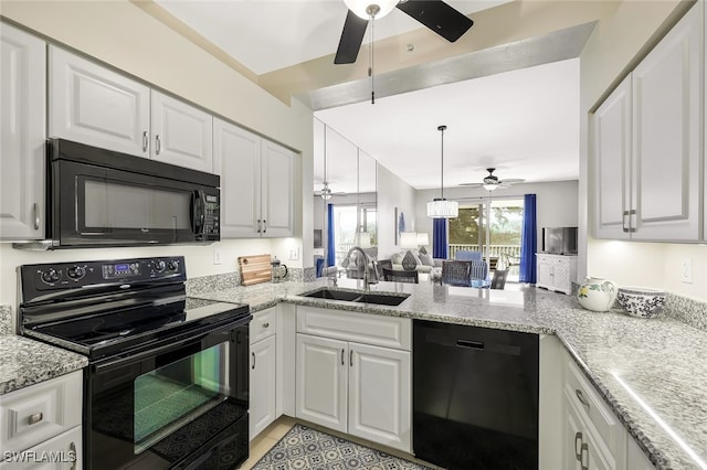 kitchen with a peninsula, a sink, white cabinets, open floor plan, and black appliances