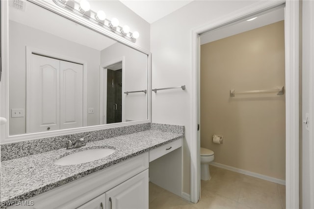 bathroom featuring a closet, tile patterned flooring, vanity, and toilet