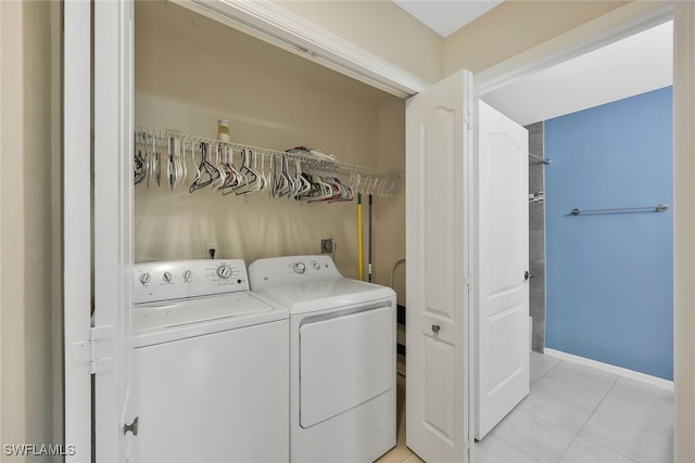 laundry room with washer and dryer, laundry area, light tile patterned flooring, and baseboards