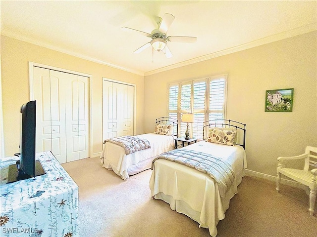 bedroom featuring light carpet, ceiling fan, ornamental molding, and multiple closets