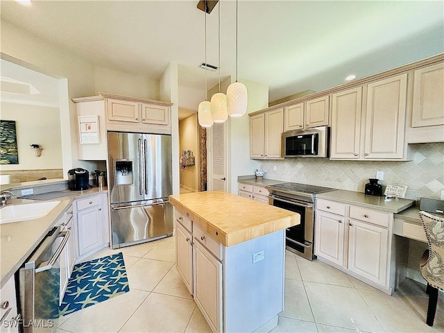 kitchen featuring appliances with stainless steel finishes, sink, a kitchen island, and light tile patterned floors