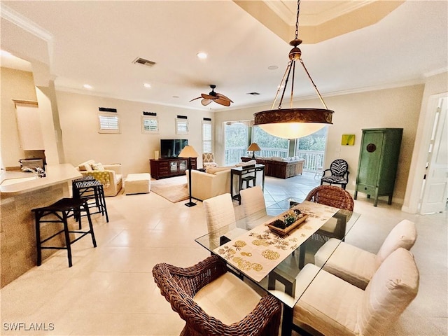 tiled dining area featuring ornamental molding, sink, and ceiling fan