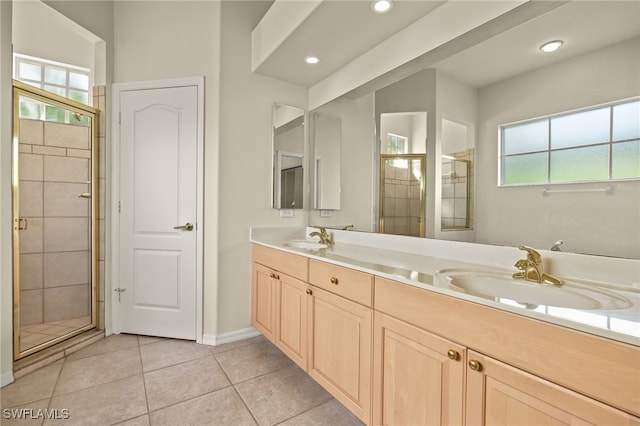 bathroom with tile patterned floors, vanity, and a shower with door