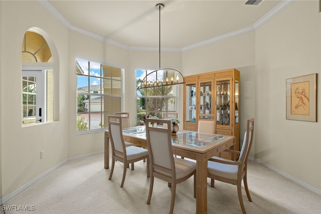 carpeted dining space with a chandelier and ornamental molding