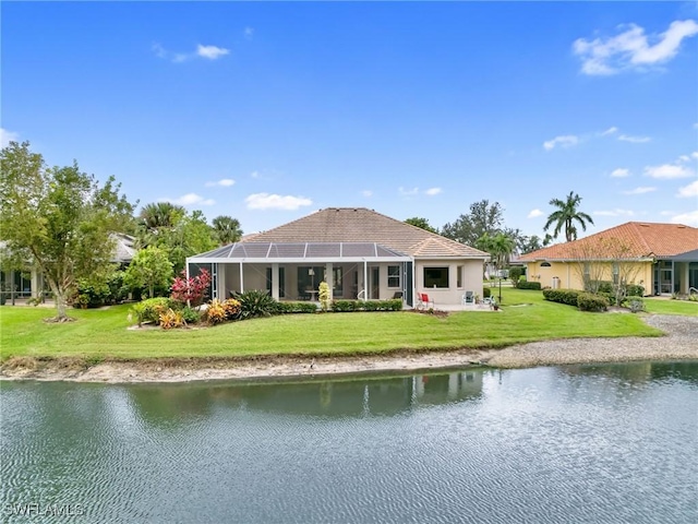 back of house with a water view, a lanai, and a lawn