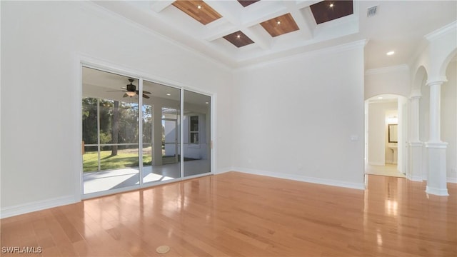 spare room with decorative columns, ornamental molding, coffered ceiling, beam ceiling, and light hardwood / wood-style flooring