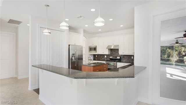 kitchen with appliances with stainless steel finishes, decorative light fixtures, white cabinetry, and ceiling fan