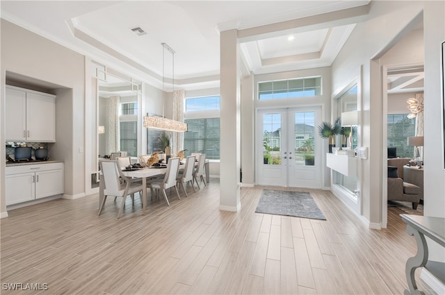 entryway featuring light hardwood / wood-style floors, french doors, crown molding, and a tray ceiling