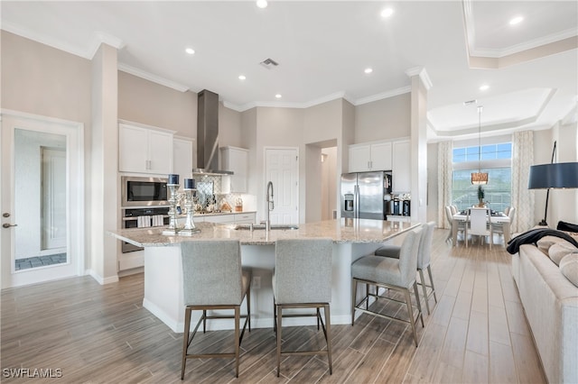 kitchen featuring a large island, white cabinetry, sink, and appliances with stainless steel finishes