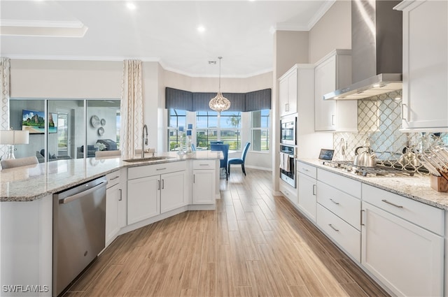 kitchen with white cabinets, stainless steel appliances, wall chimney exhaust hood, and sink