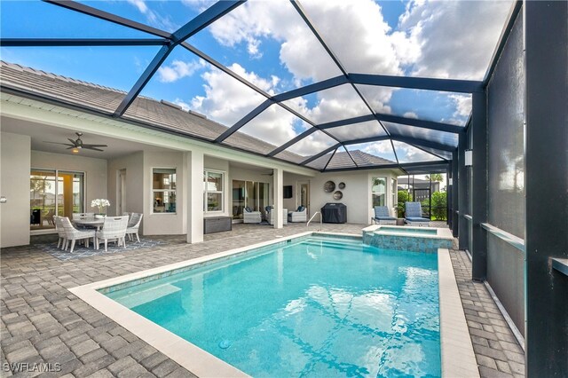 view of swimming pool with a lanai, a patio area, an in ground hot tub, and ceiling fan