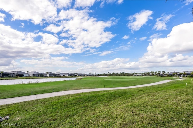 surrounding community featuring a water view and a lawn