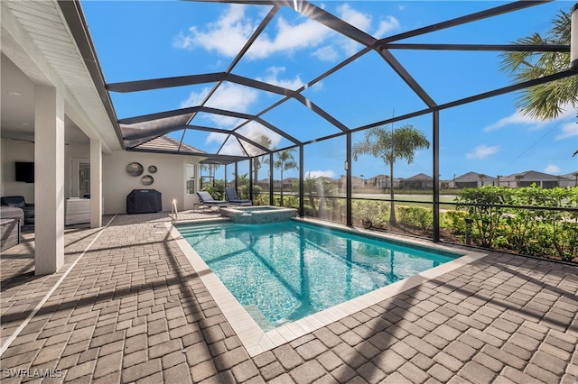 view of swimming pool featuring an in ground hot tub, a patio, and a lanai