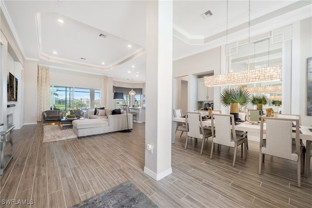 living room with a raised ceiling and ornamental molding