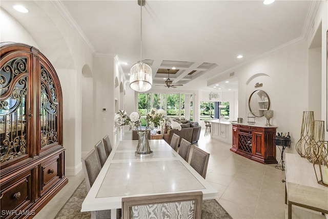 dining area with coffered ceiling, beamed ceiling, crown molding, light tile patterned flooring, and ceiling fan with notable chandelier