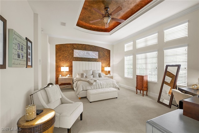 carpeted bedroom featuring a raised ceiling, ceiling fan, and crown molding