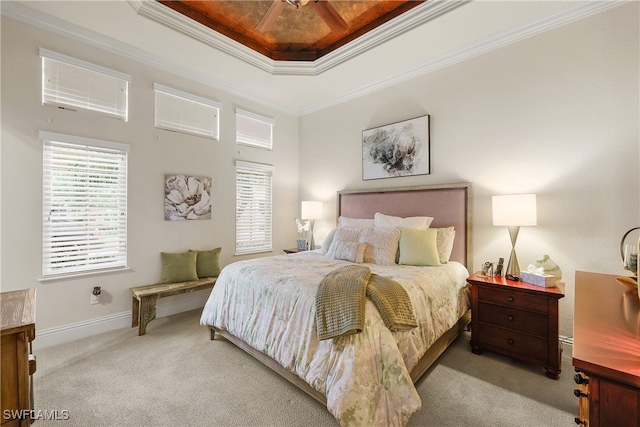 carpeted bedroom with a tray ceiling, ceiling fan, and ornamental molding