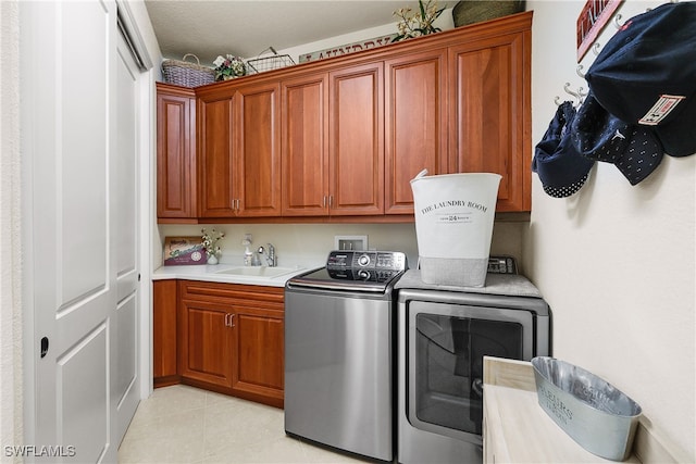 clothes washing area featuring cabinets, independent washer and dryer, light tile patterned floors, and sink