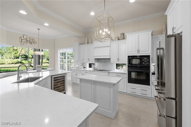 kitchen with a large island, wine cooler, pendant lighting, white cabinets, and black appliances