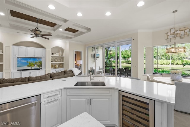 kitchen featuring beam ceiling, white cabinetry, sink, wine cooler, and ornamental molding