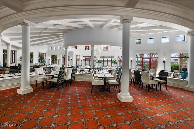 unfurnished dining area with carpet flooring and beamed ceiling