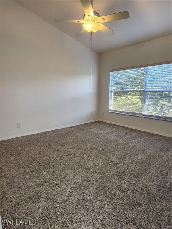 carpeted spare room with ceiling fan