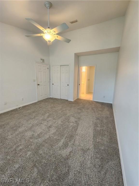 unfurnished bedroom featuring carpet, a closet, and ceiling fan