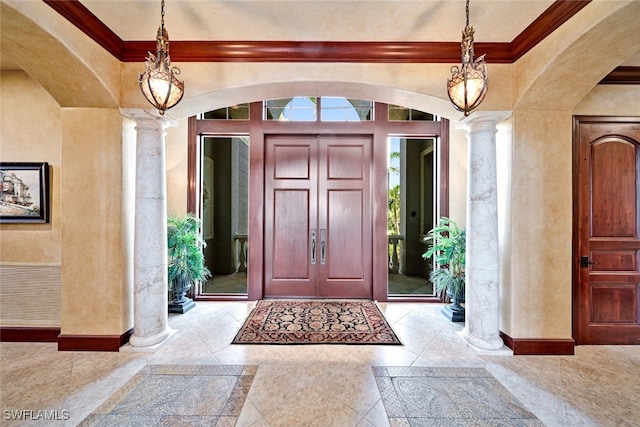 foyer with decorative columns and ornamental molding