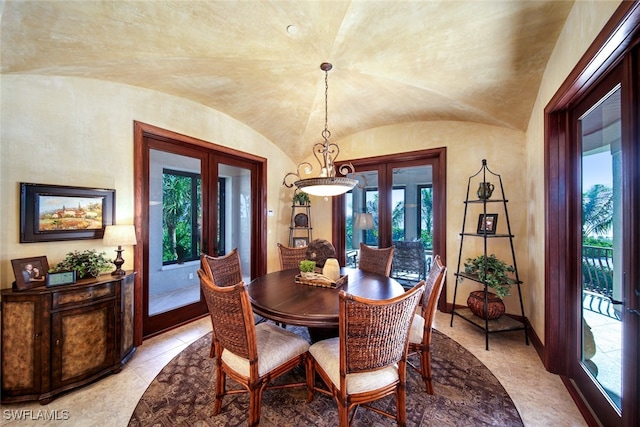 tiled dining space with french doors and lofted ceiling