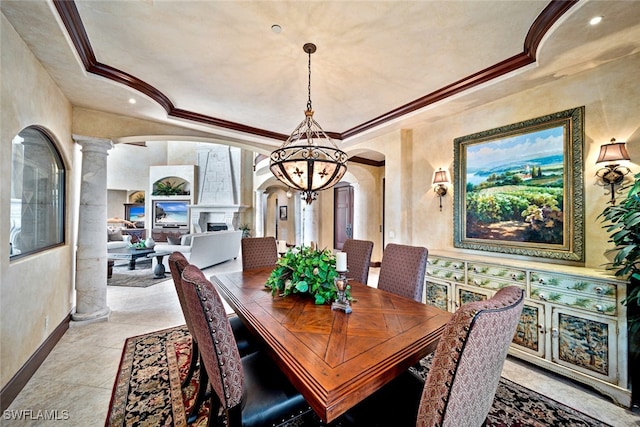 dining area featuring ornate columns, ornamental molding, and a chandelier