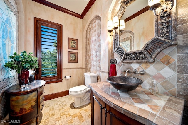 bathroom with vanity, toilet, ornamental molding, and decorative backsplash