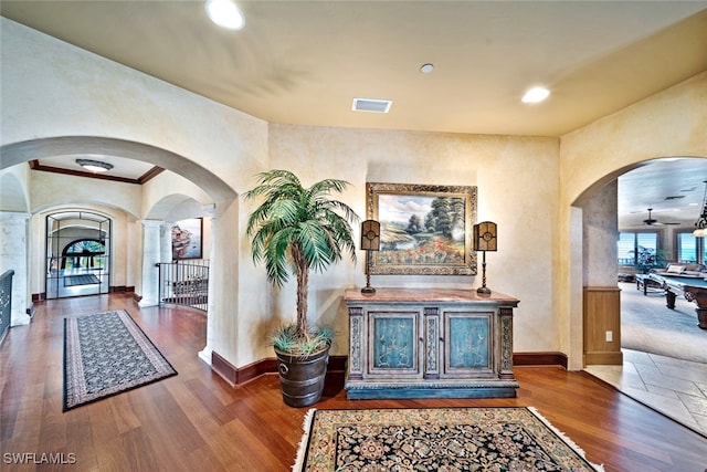 hallway with hardwood / wood-style floors and ornate columns