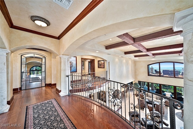 corridor with ornate columns, coffered ceiling, dark hardwood / wood-style flooring, beamed ceiling, and crown molding